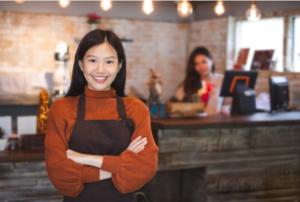 Smiling restaurant employee in front of cash register